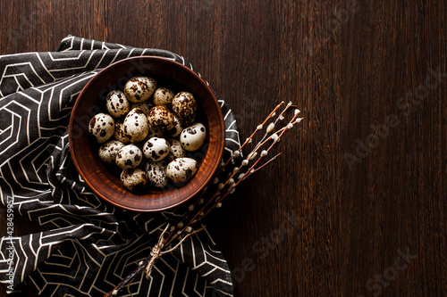 Quail eggs in a clay plate on a dark background