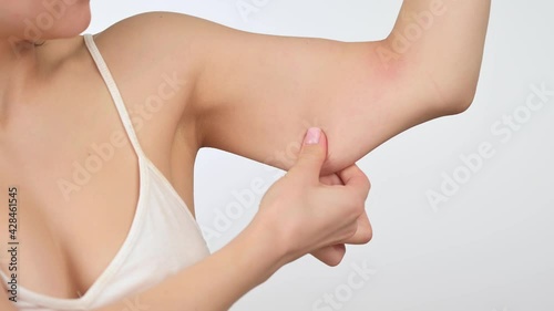 Young woman touching flabby muscles triceps