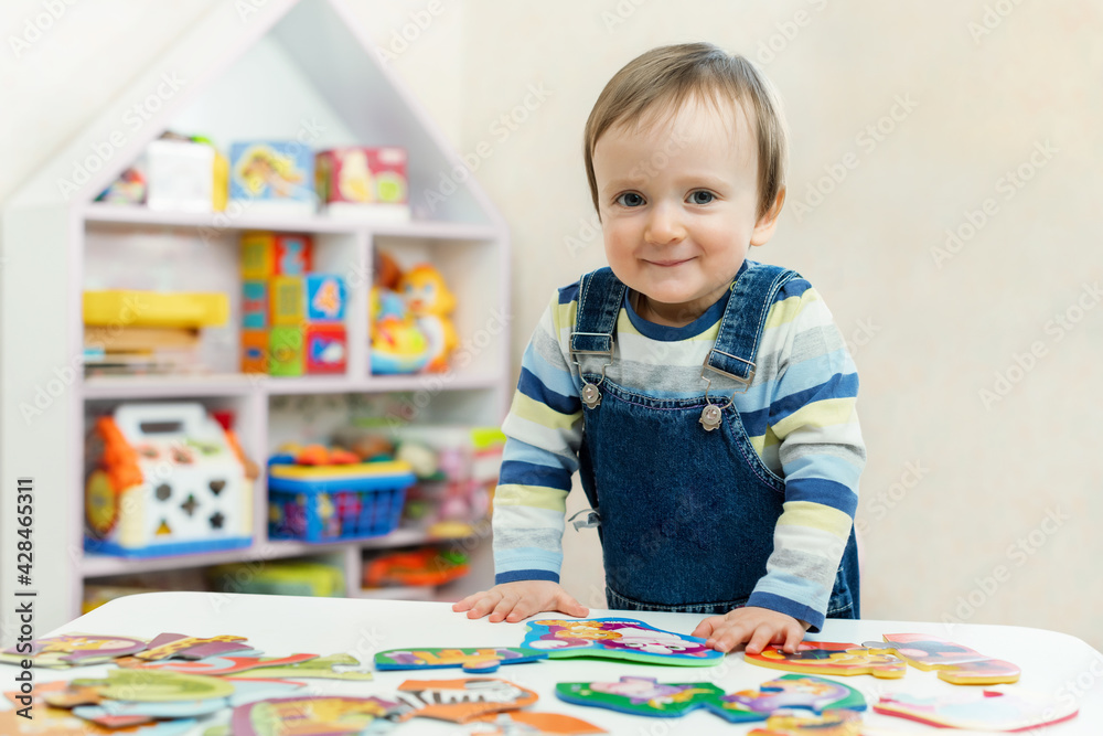 Fototapeta premium The child doing puzzle. Educational logic toys for kid's.