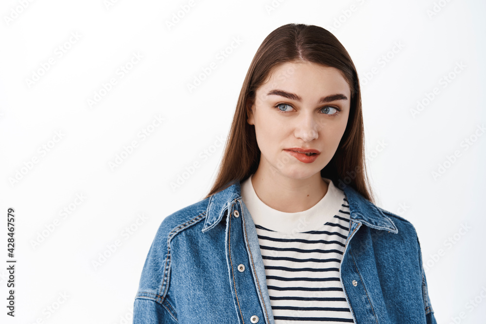 Thoughtful woman wants something badly, bites lower lip and looks aside at promotional text copyspace, desire, tempted to try, standing over white background Thoughtful woman wants something badly, bites lower lip and looks aside at promotional text copyspace, desire, tempted to try, standing over white background