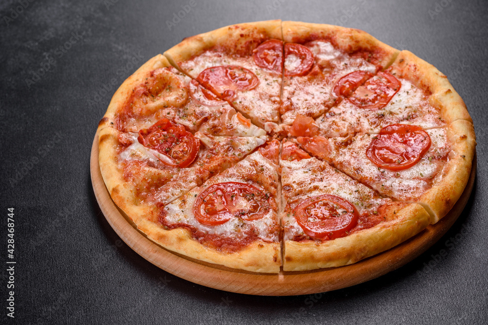 Tasty fresh oven pizza with tomatoes, cheese and basil on a concrete background Tasty fresh oven pizza with tomatoes, cheese and basil on a concrete background