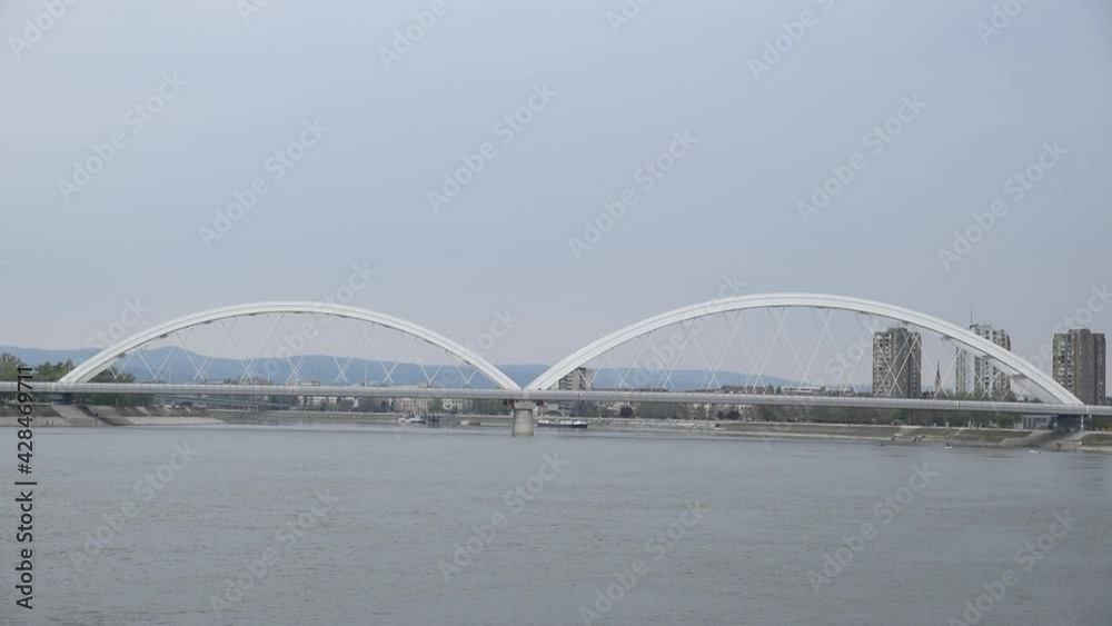 New Serbian Zezelj bridge with arc over the Danube river with architectural lines and cloudy sky above in the city of Novi Sad, Serbia on cold rainy weather New Serbian Zezelj bridge with arc over the Danube river with architectural lines and cloudy sky above in the city of Novi Sad, Serbia on cold rainy weather