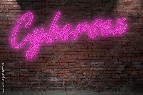 Neon Cybersex lettering on Brick Wall at night