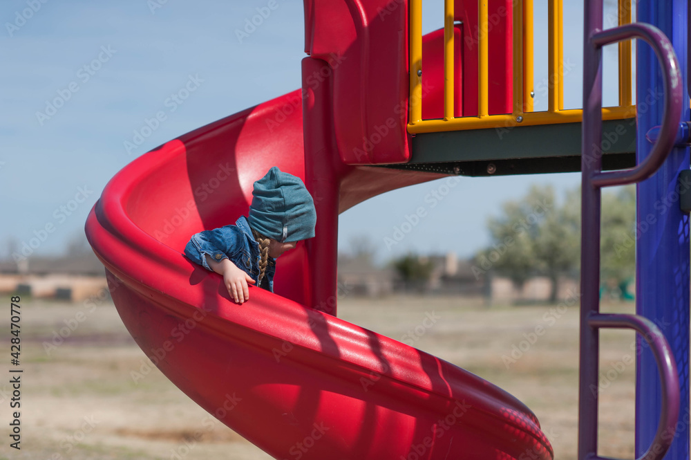 Girl sliding down slide at playground Stock Photo Adobe Stock