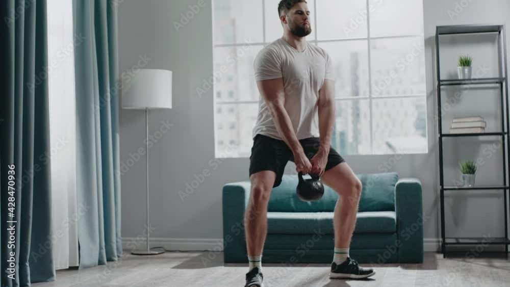 Concentrated muscular guy with beard practices squats Concentrated muscular guy with beard practices squats