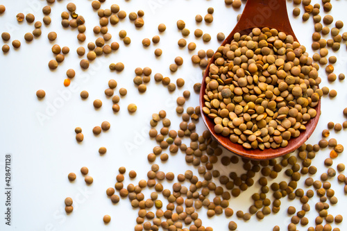 Organic raw green lentil over wooden tray and sackcloth, studio image