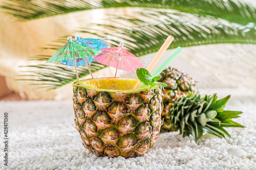 Drink in pineapple with drinking straw. Drink for summer heat.