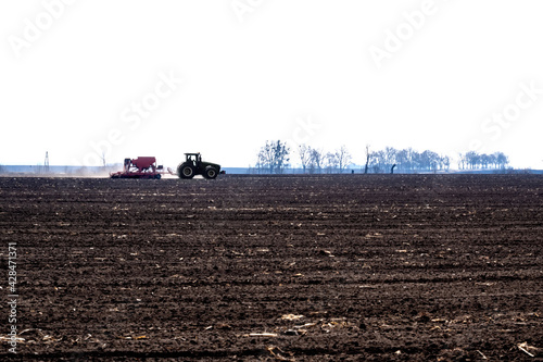 tractor with seeder in the field in early spring