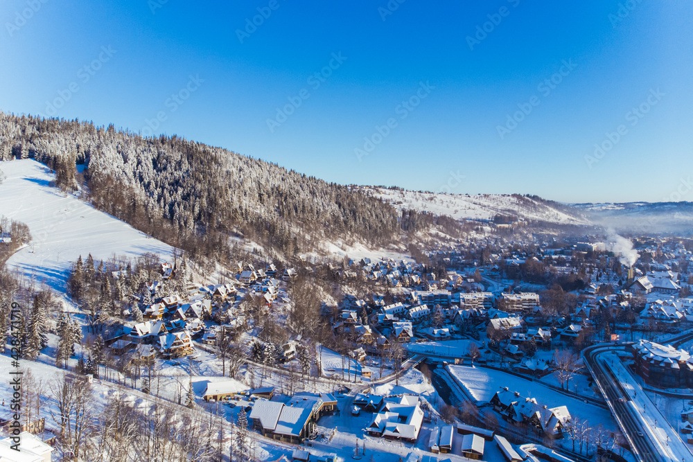 Beautiful winter scenery of houses roads and evergreen forest covered in snow on winter morning. Aerial. High quality 4k footage