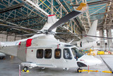 Passenger helicopter and airplanes under maintenance. Checking mechanical systems for flight operations. Rotorcraft and aircrafts in the hangar