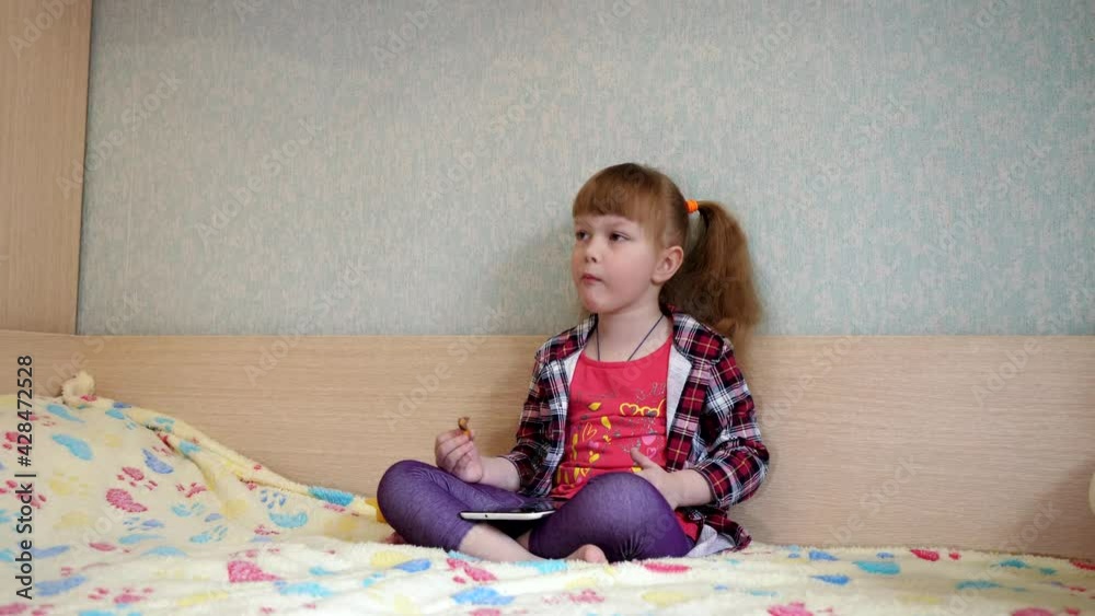 happy child little girl using tablet computer sitting on bed happy child little girl using tablet computer sitting on bed