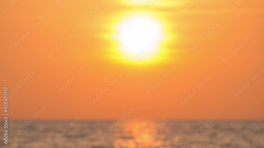 Sunset in golden Sky at sea. Timelapse of the big bright sun moves down. seascape and silhouette of sea waves on the horizon. golden colors of setting sun. Vibrant color nature landscape background Sunset in golden Sky at sea. Timelapse of the big bright sun moves down. seascape and silhouette of sea waves on the horizon. golden colors of setting sun. Vibrant color nature landscape background