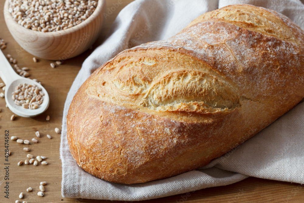 A loaf of bread and wheat grains