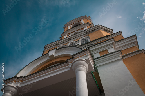 the bell tower of the orthodox church on the background of a blue cloudy sky