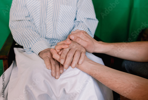 Canvas-taulu hands of an old and young man close-up. old age and youth