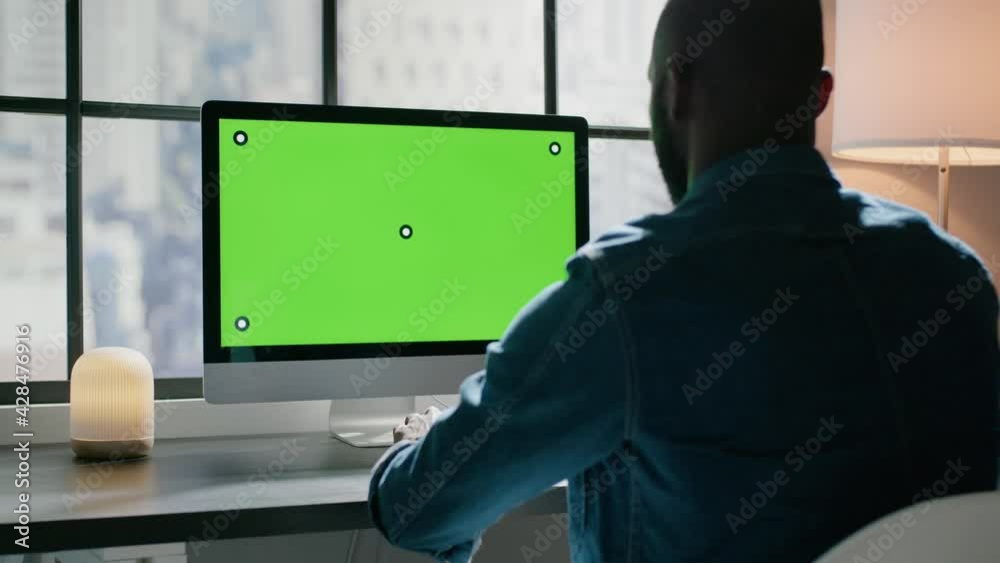 Black man works on project on computer with tracking markers