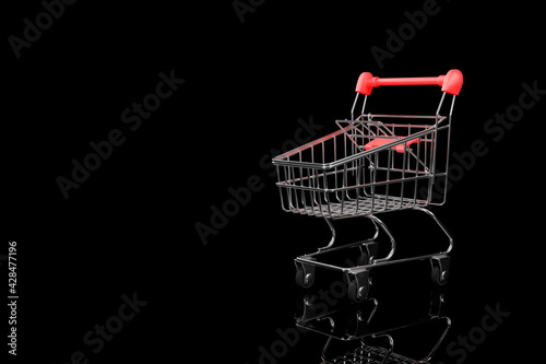 Supermarket trolley close-up on a black background.3D rendering.