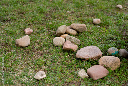 Three stones on vivid green grass field; Background