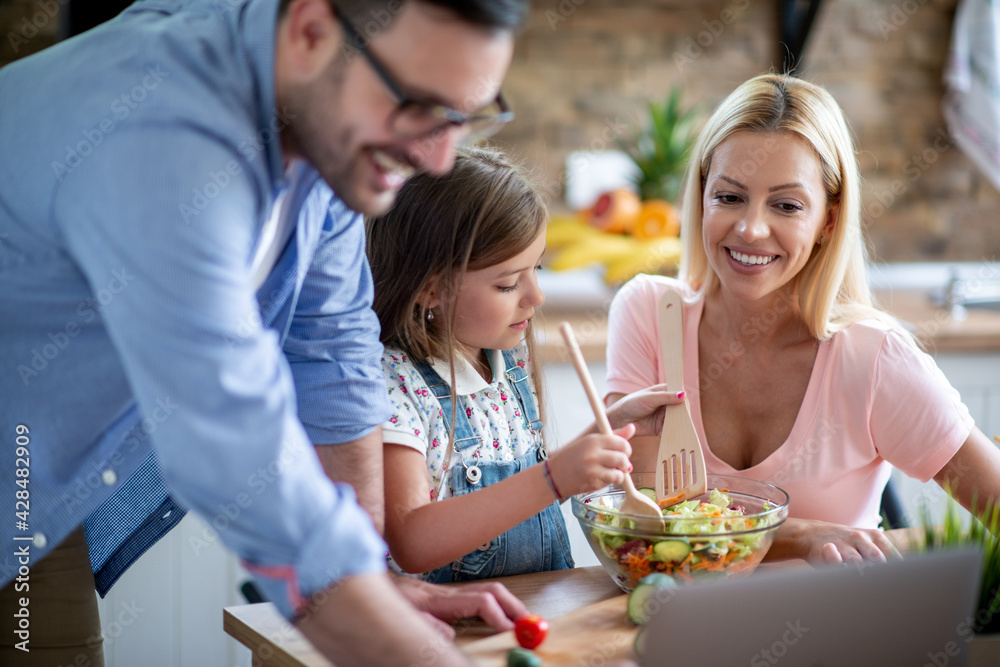 Family using laptop during cooking in kitchen