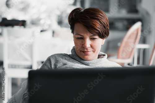 Kobieta pracuje na laptopie w domu, praca zdalna z domu