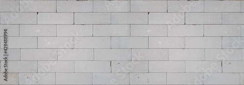 A fragment of a white wall made of blocks, rough masonry, texture or wallpaper
