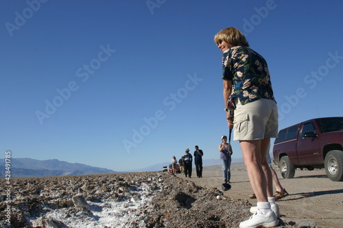 Woman Playing Golf in Death Valley, California, Checking Ready to T-Off at the Devil's Golf Course