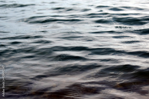 Clean water abstract wave and sky reflection texture on rapid flowing rocky river surface. lake shore nature pattern ecology background