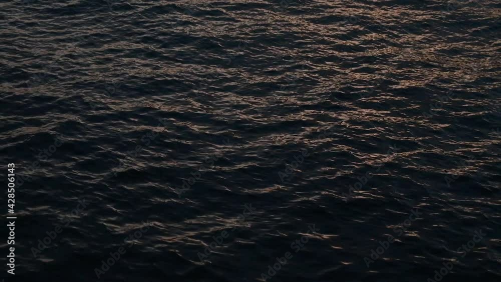 Water surface with small waves during sun set