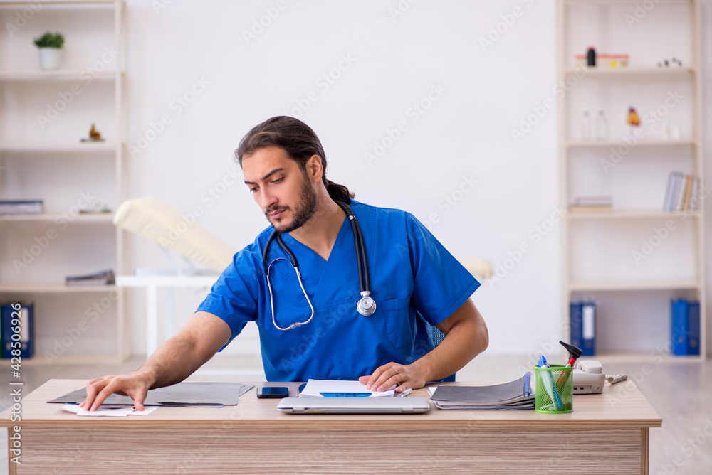Young male doctor working in the clinic Young male doctor working in the clinic