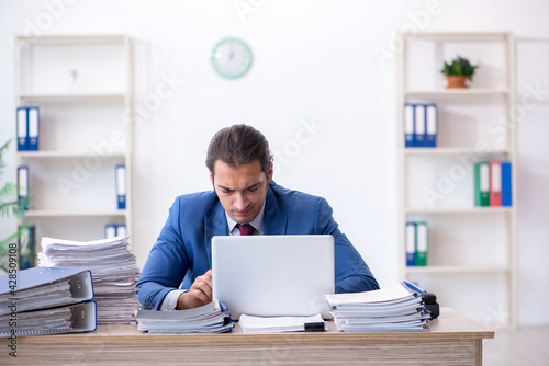 Young male employee unhappy with excessive work in the office