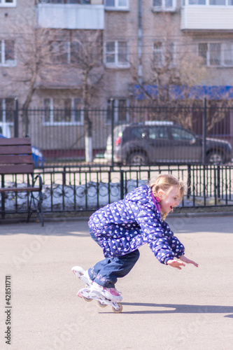On a warm spring evening, a girl learns to rollerblade and falls.