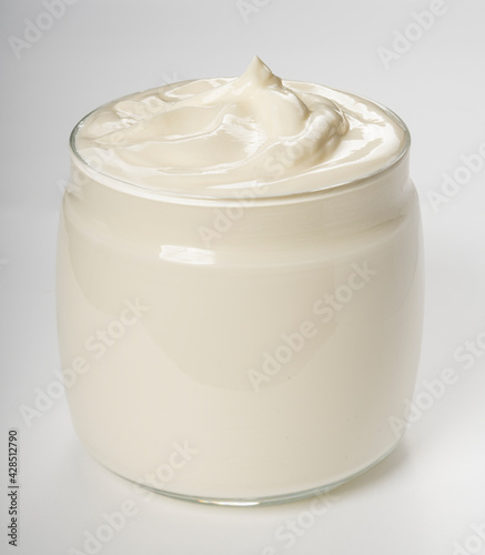 Sour cream in glass jar isolated on white background