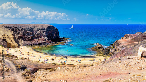 Landscape of a beach surrounded by rocks formations and sea under the sunlight in Lanzarote, Spain