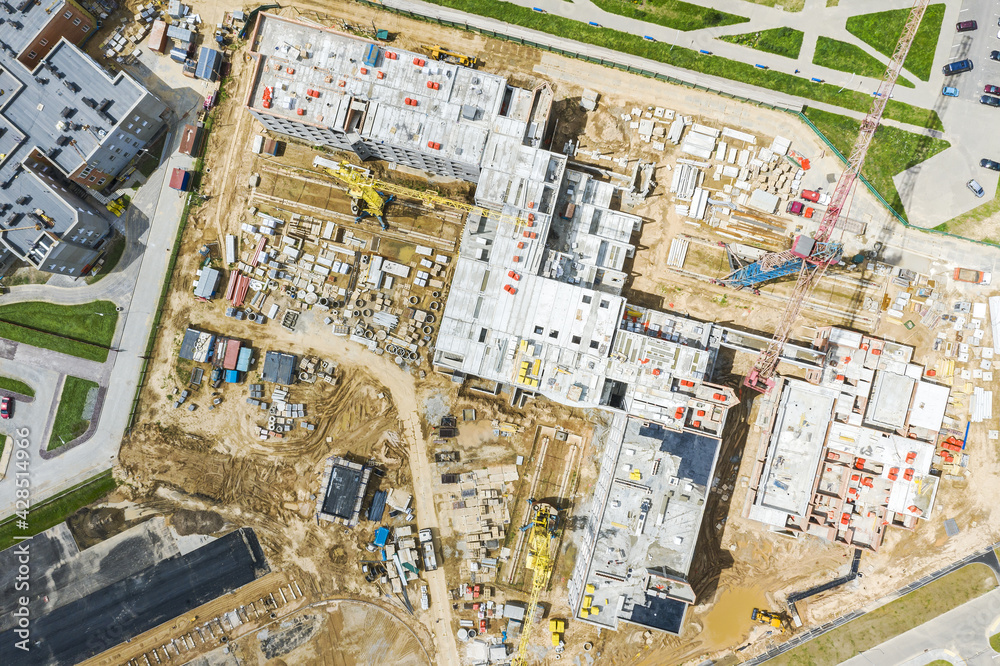 Fototapeta premium busy construction site of residential area building with working cranes. aerial top view