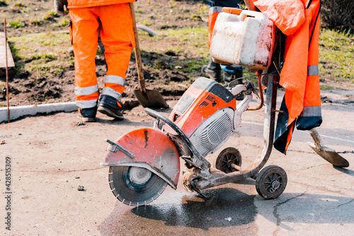 Slika na platnu Orange huge tile, concrete or asphalt cut-off saw stand on the ground during the repair works on the sidewalk