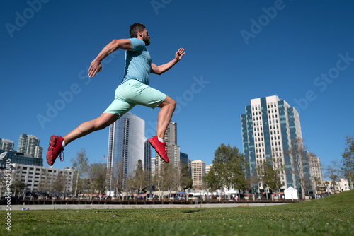 Athletic young man running in city. Dynamic jumping movement. Young and active jogger running. Urban sport concept.