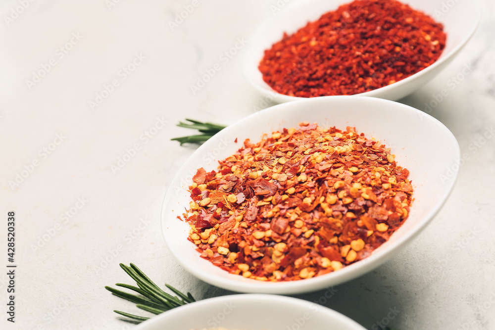 Bowls with spices and rosemary on light background, closeup Bowls with spices and rosemary on light background, closeup