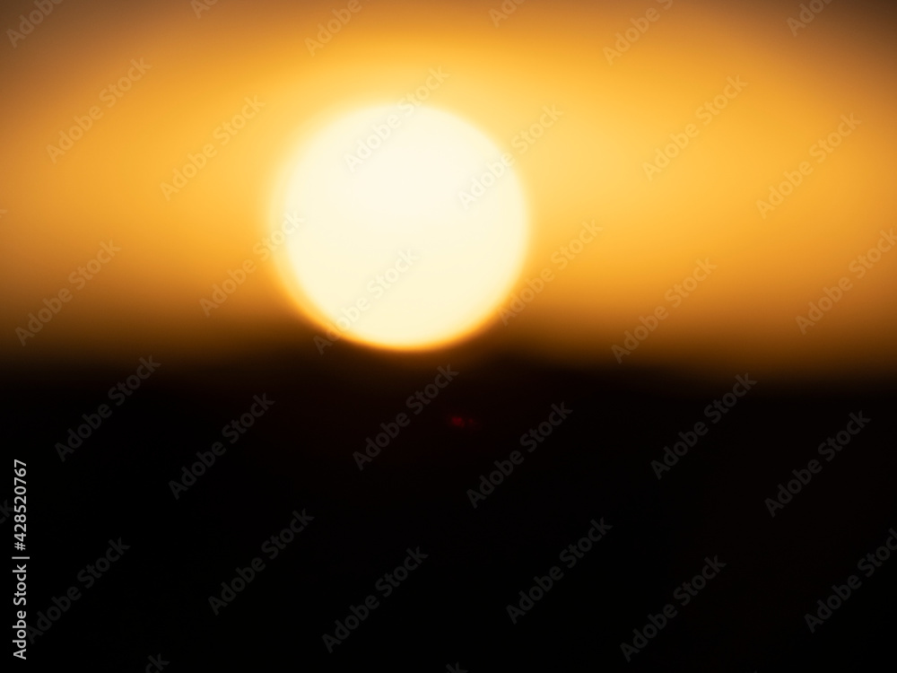 Serengeti National Park, Tanzania, Africa - February 29, 2020: Large sun setting over the serengeti Serengeti National Park, Tanzania, Africa - February 29, 2020: Large sun setting over the serengeti