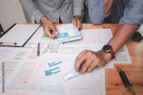 UX or UI designers designing on their smartphone application layout prototype project.