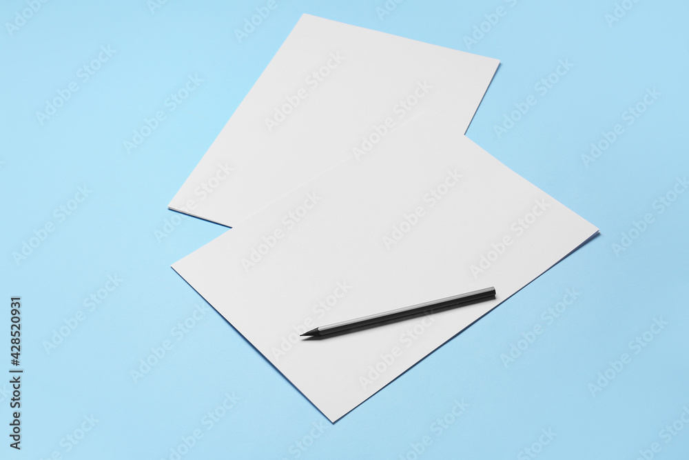 Blank sheets of paper and pencil on color background Blank sheets of paper and pencil on color background