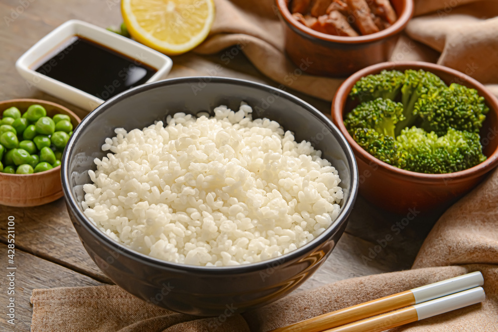Bowl with tasty rice on wooden background, closeup Bowl with tasty rice on wooden background, closeup