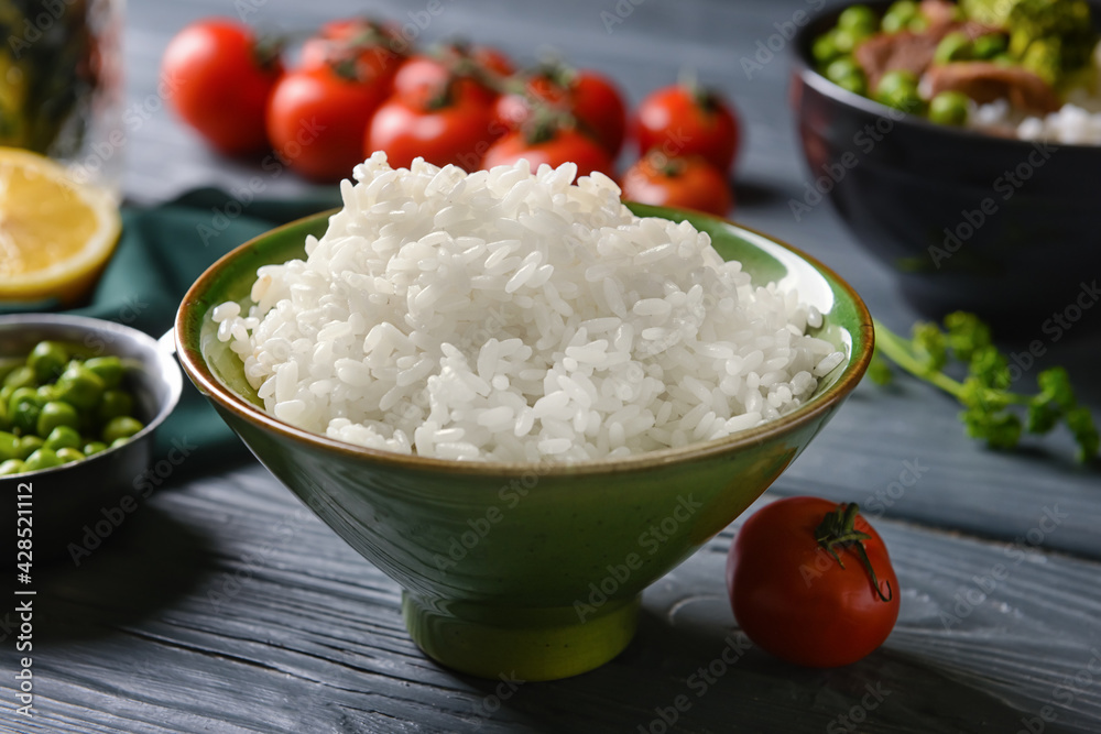 Bowl with tasty rice and vegetables on dark wooden background Bowl with tasty rice and vegetables on dark wooden background
