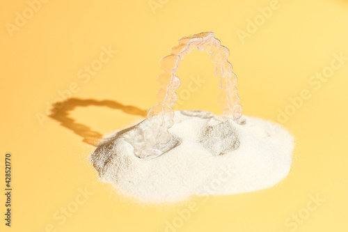 Orthodontic dental theme on yellow surface. transparent invisible dental aligners or braces aplicable for an orthodontic dental treatment photo