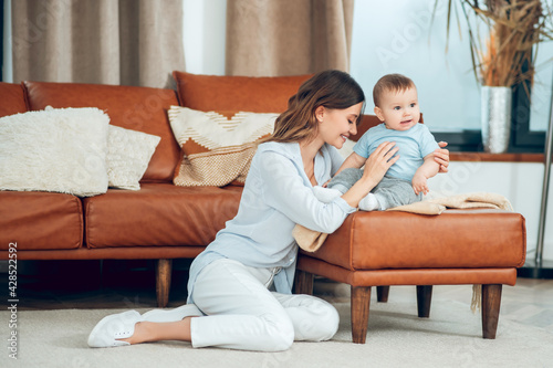 Woman sitting on floor near child on couch