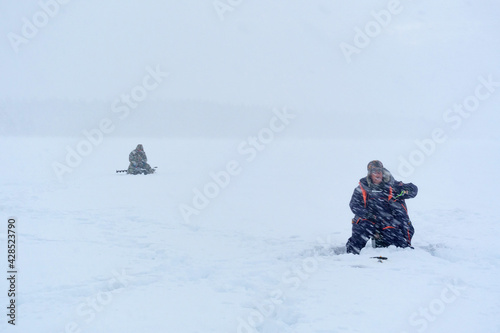 fishermen catch fish in winter in heavy snowfall. soft focus