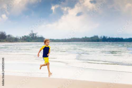 Kids playing on beach. Children play at sea. © famveldman