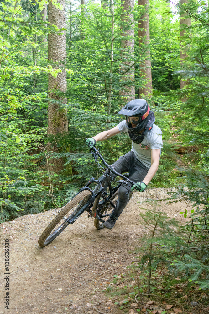 Mountainbiker befährt einen Waldtrail in einem Bikepark