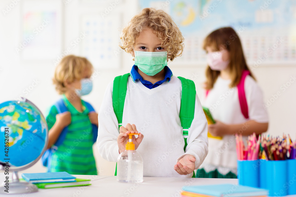 Hand sanitizer in school. Child in face mask. Hand sanitizer in school. Child in face mask.