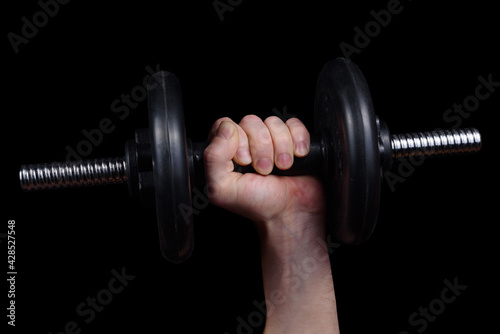 In cancer of a man a large dumbbell on a black background.