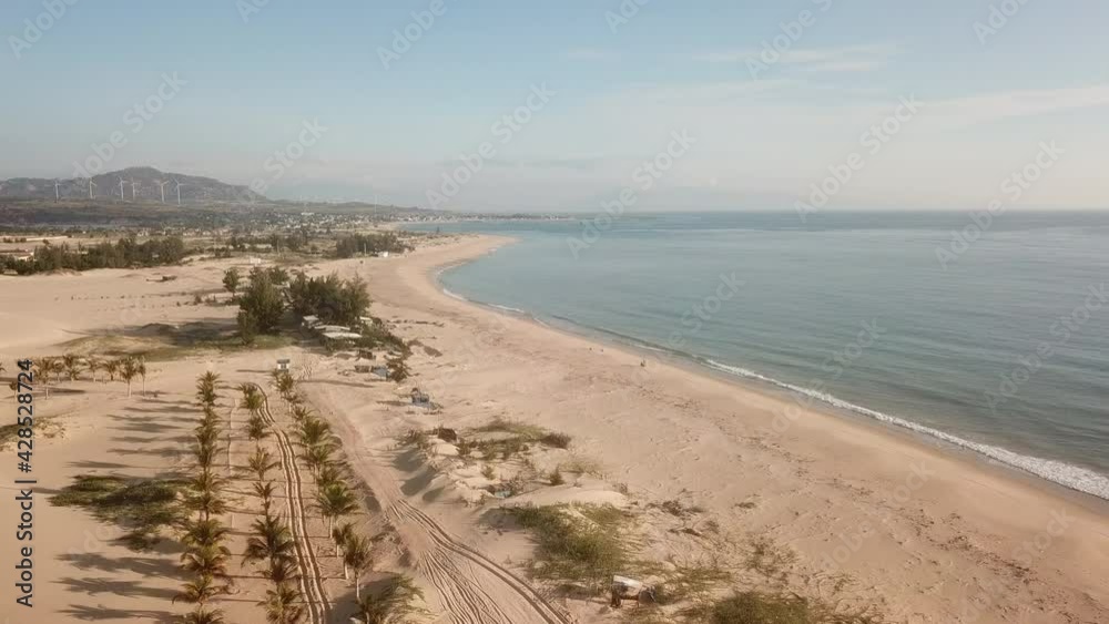 The drone flies going through the sand dunes towards the sea. Aerial Drone Footage high above the beach with the ocean. The drone flies going through the sand dunes towards the sea. Aerial Drone Footage high above the beach with the ocean.